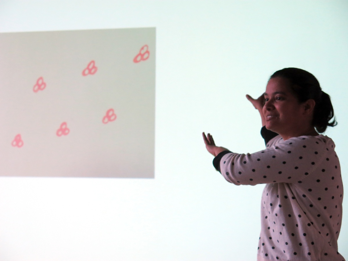 Event photograph from the 2018 rendition of the City Research Studio exchange with the African Centre for Cities. An individual is standing in front of a wall with a projection of a group of small drawings.
