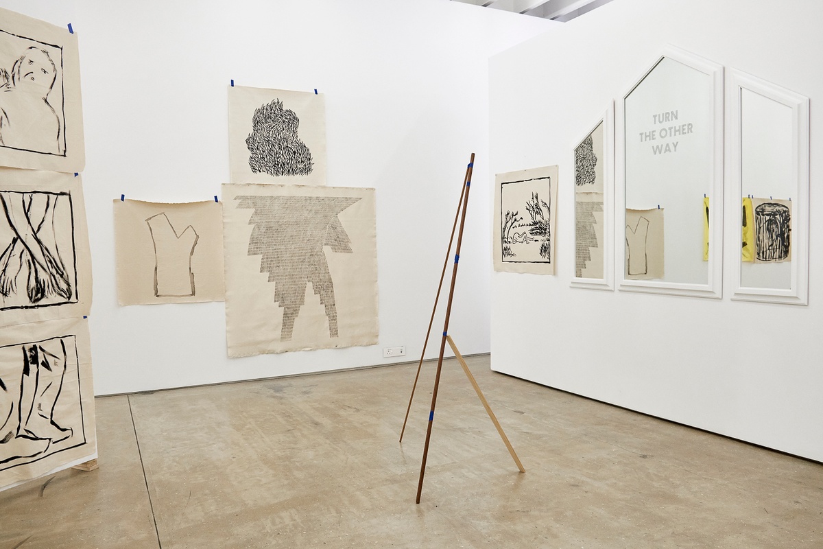Installation photograph from the 2018 rendition of ‘Parallel Play’ in A4’s Gallery. On the right, Haroon Gunn-Salie’s mirror work ‘Turn the other way’ is mounted on a moveable gallery wall. On the left, Jonah Sack’s paper drawings are taped onto the wall and a freestanding board.
