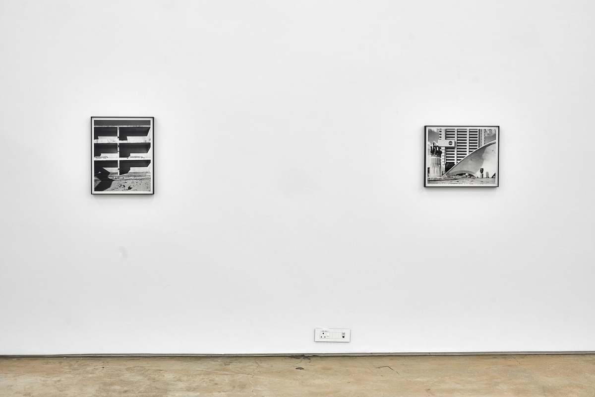 Installation photograph from the ‘Picture Theory’ exhibition in A4’s Gallery. On the left, David Goldblatt’s monochrome photograph “Miners’ bunks in the abandoned Chinese compound, so called because it probably housed indentured Chinese labourers between 1904 and 1910, after which it accommodated black miners. Simmer & Jack Gold Mine, Germiston” is mounted on the gallery wall. On the right, Goldblatt’s monochrome photograph ‘The monument at left celebrates the fifth anniversary of the Republic of South Africa. The one at right is to J G Strijdom, militant protagonist of White supremacy and of an Afrikaner republic, who died in 1958. At rear is the headquarters building of Volkskas (‘The People’s Bank’) founded in 1934 to mobilise Afrikaner capital and to break the monopoly of the ‘English’ banks. Pretoria’ is mounted on the gallery wall.
