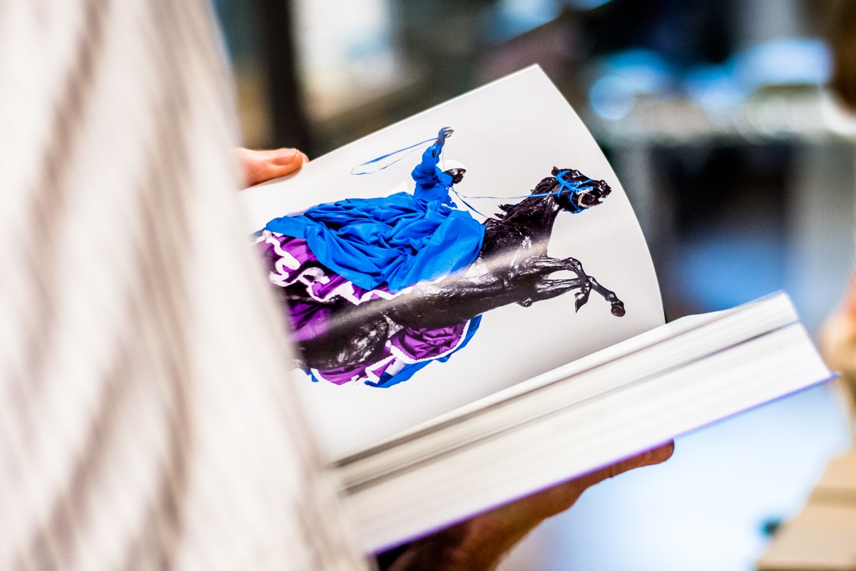 Event photograph from the book launch of Ashraf Jamal’s ‘In the World: essays on contemporary South African art’ on A4’s top floor, that depicts a closeup view of an individual paging through the book.
