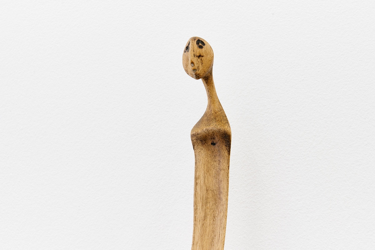 Installation photograph from the 'A Little After This' exhibition in A4 Arts Foundation's gallery that shows a detail of Lucas Sithole's carved yellowwood sculpture 'Not You!'.
