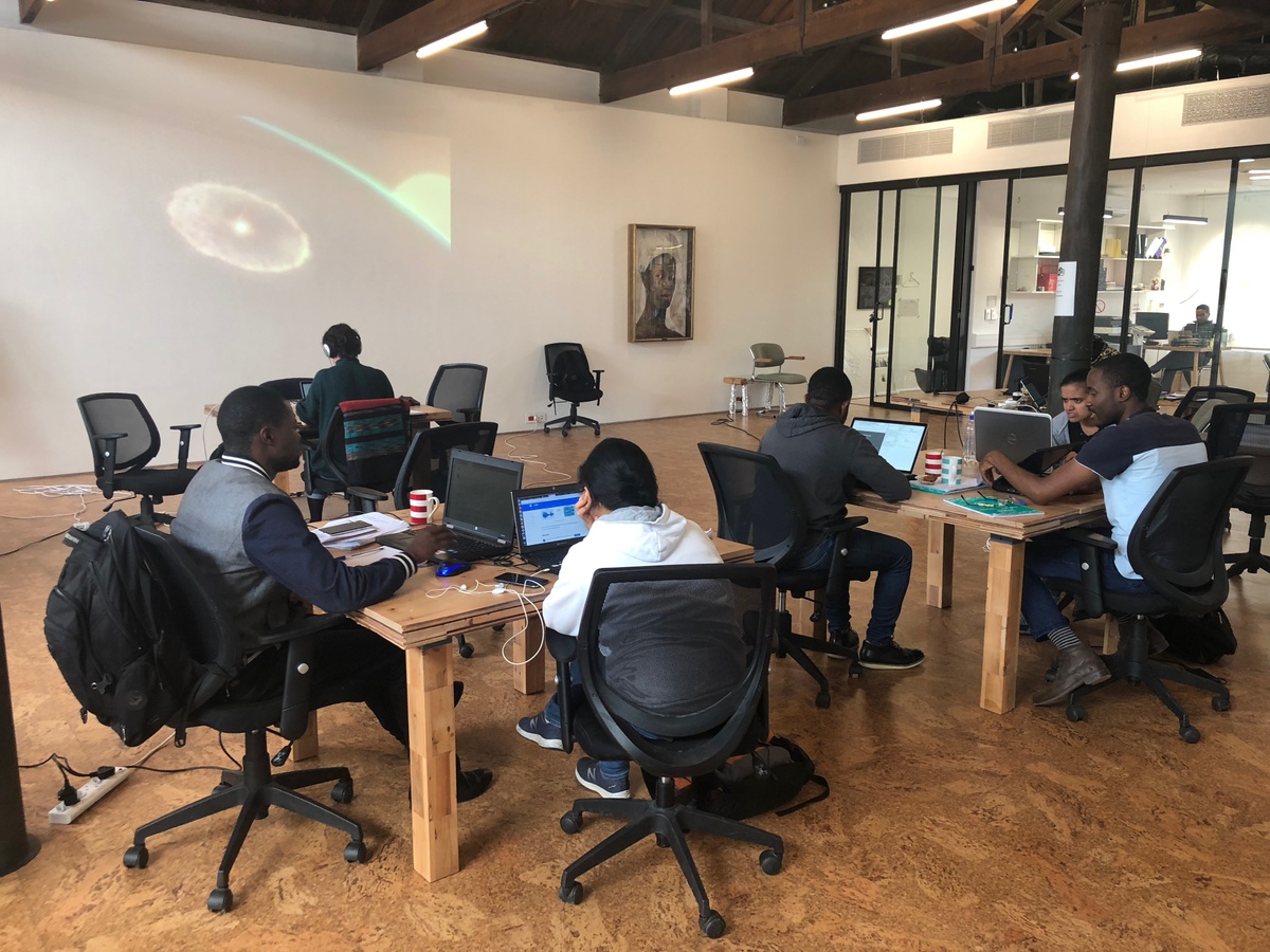 Process photograph from the ‘Data Science Intensive’ event with the AIMS Institute for Mathematical Sciences on A4’s top floor that shows participants seated around workstations.
