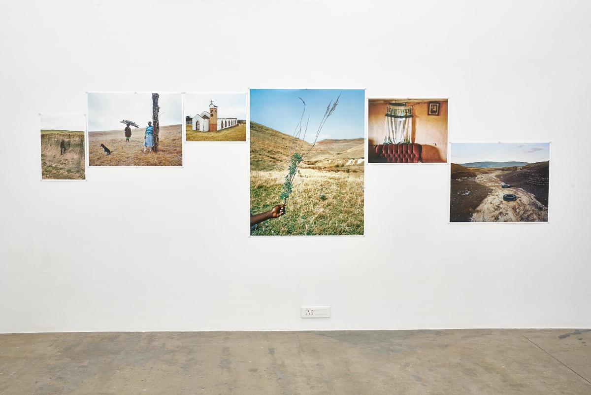 Installation photograph from the ‘Tell it to the Mountains’ exhibition in A4’s Gallery. Lindokuhle Sobekwa’s colour photographs ‘uMthembu omncinci’, ‘Omama bathwelinyanda’, ‘eDonkey Church’, ‘Mhlonyane’, ‘Kwa Malume Mxolisi’ and ‘Ezindongeni zase Khwezane’ are mounted on the wall.
