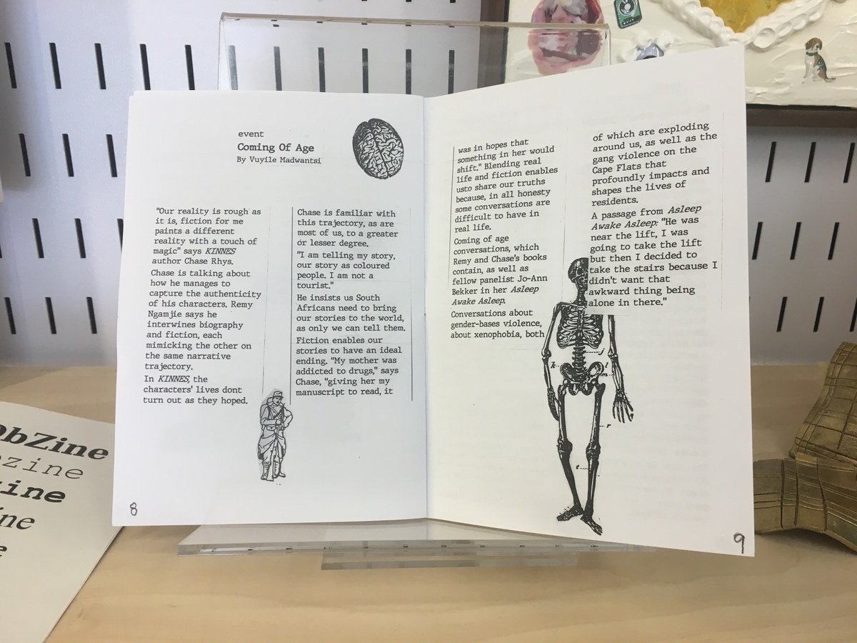 Photograph of the ‘OBZine’ publication from the 2019 rendition of the Open Book Literary Festival, with contributions from various student writers. A two-page spread features Vuyile Madwantsi’s text ‘Coming Of Age’, with drawings of a human skeleton, a human brain and a rifle carrying soldier.
