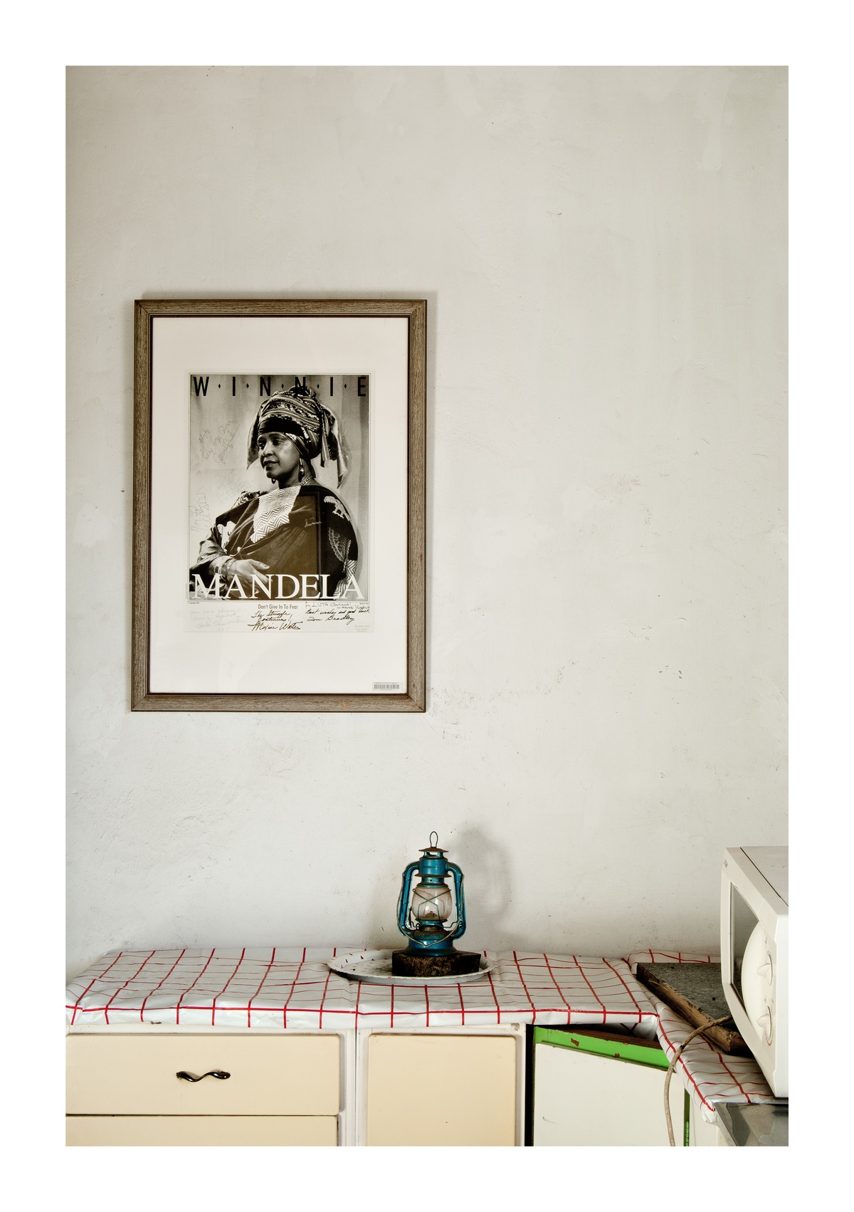 Photograph ‘Kwa Mamtshali, Phiri, Soweto’ from Jabulani Dhlamini’s residency on A4’s top floor. At the front, an oil lantern sits on kitchen cupboard. At the back, a framed photograph of Winnie Mandela is mounted on the wall.
