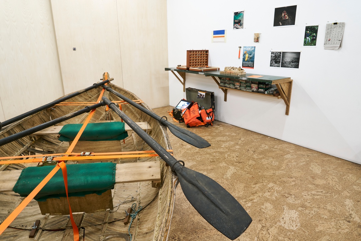 Installation photograph from ‘Archive as Terrarium: Part 3’ on A4’s top floor. On the left, Christian Nerf, Douglas Gimberg and barend de wet’s ‘Escape to Robben Island (Angasi Nkosi Angasi Nkosi)’ sits on the floor. On the right, Nerf, Gimberg and de wet’s ‘Escape to Robben Island (evidence)’ sits on the floor under a wall mounted shelf.
