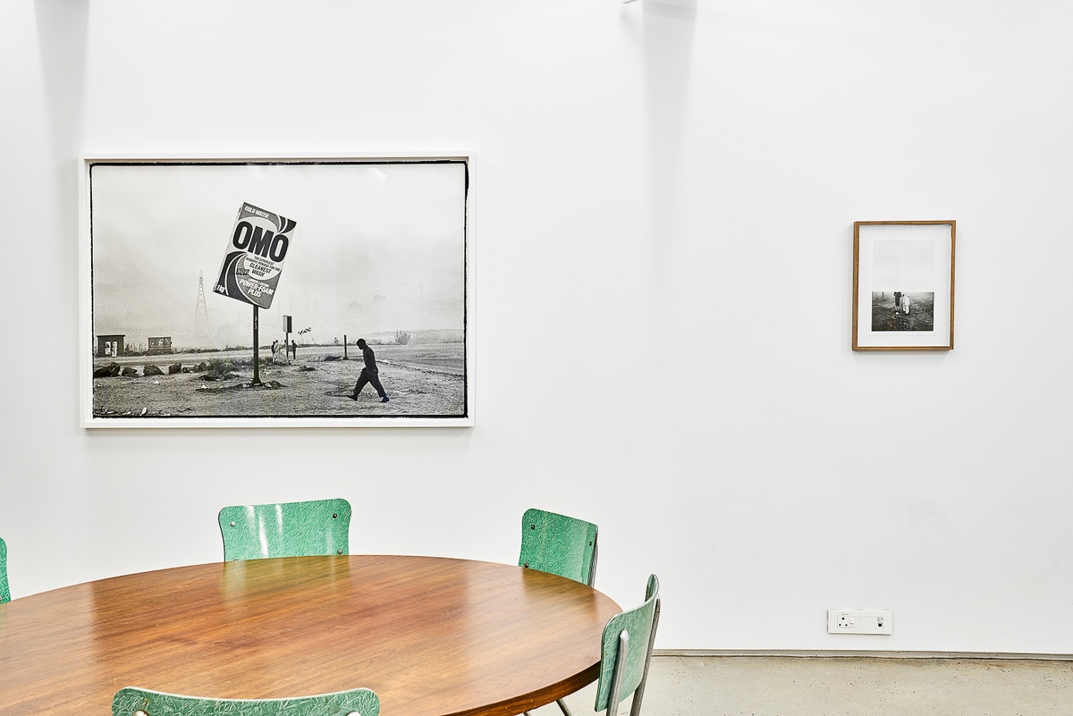 Installation photograph from the ‘Nowhere - No we're - Now here’ exhibition on A4’s ground floor. On the left, Santu Mofokeng’s photograph ‘Winter in Tembisa’ is mounted on the gallery wall. On the right, Sabelo Mlangeni’s photograph ‘A morning after (UmlindeloUmlindelo wamaKholwa)’ is mounted on the gallery wall.
