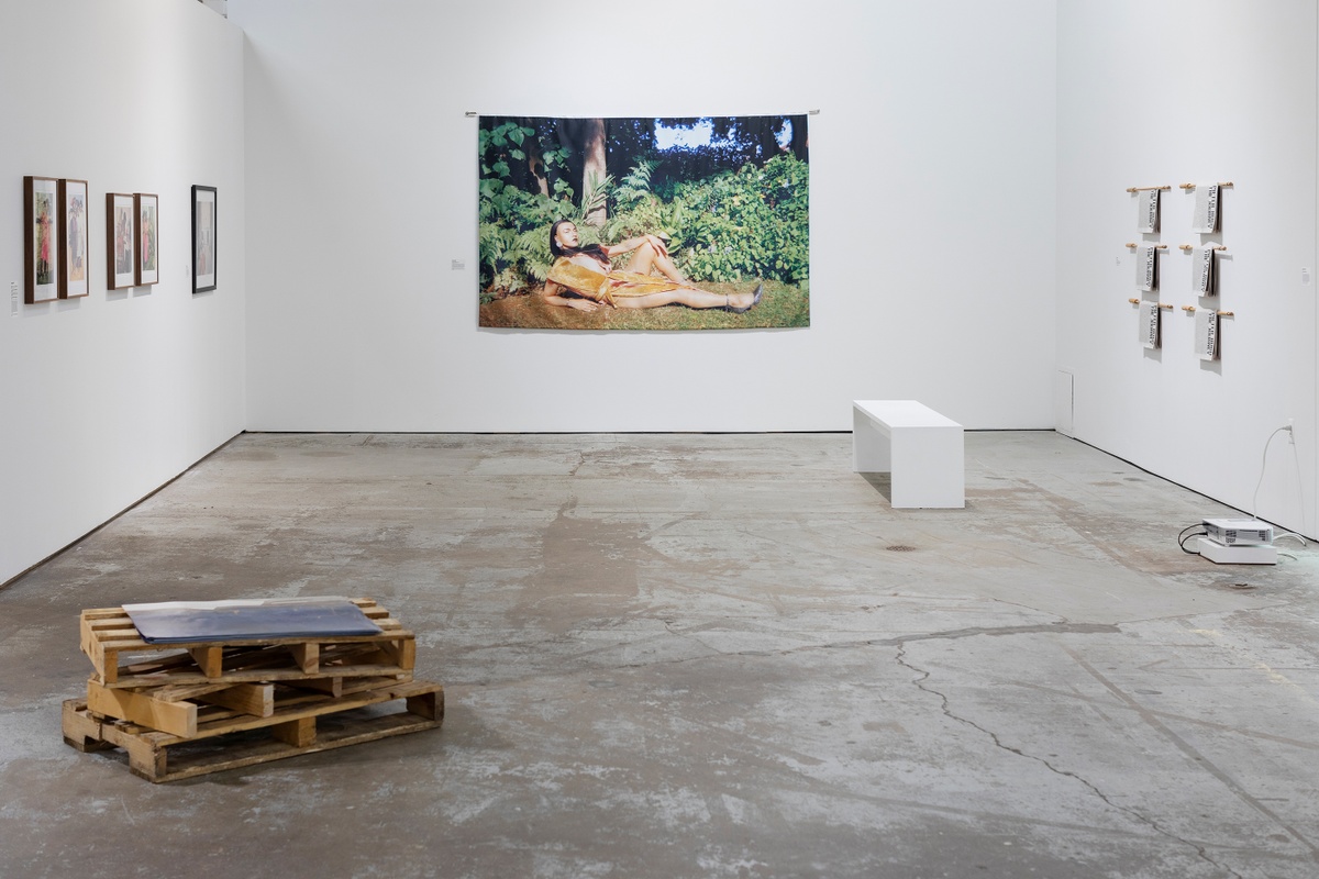 Installation photograph from ‘Crossing Night: Regional Identities x Global Context’ exhibition at the Museum of Contemporary Art Detroit. On the left, Edson Chagas’ installation ‘Found not taken’ sits on the gallery floor. In the back, Jody Brand’s photograph ‘Moffie in Irma's Garden’ is mounted on the gallery wall. On the right, Pieter Hugo’s photographic series and text ‘The Journey’ in the form printed newspaper booklets are hung on the wall.
