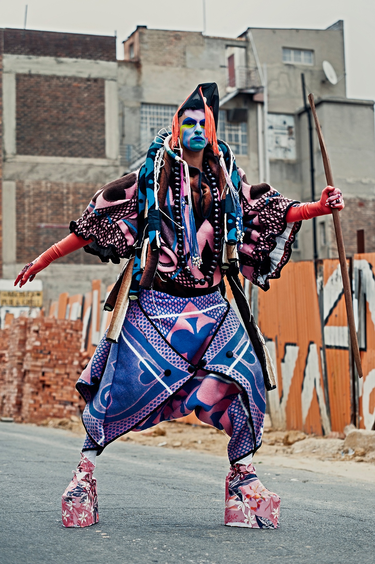 Photographic ephemera from Kieron Jina’s residency at A4 that depicts the artist in costume and face paint against a backdrop of construction materials.
