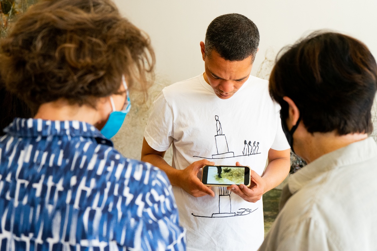 Event photograph from ‘Knots’, a conversation between Igshaan Adams and Josh Ginsburg, marking the close of ‘Open Production’, Adams’ hybrid studio/exhibition in A4’s Gallery. At the back, Adams shares a video with attendees.
