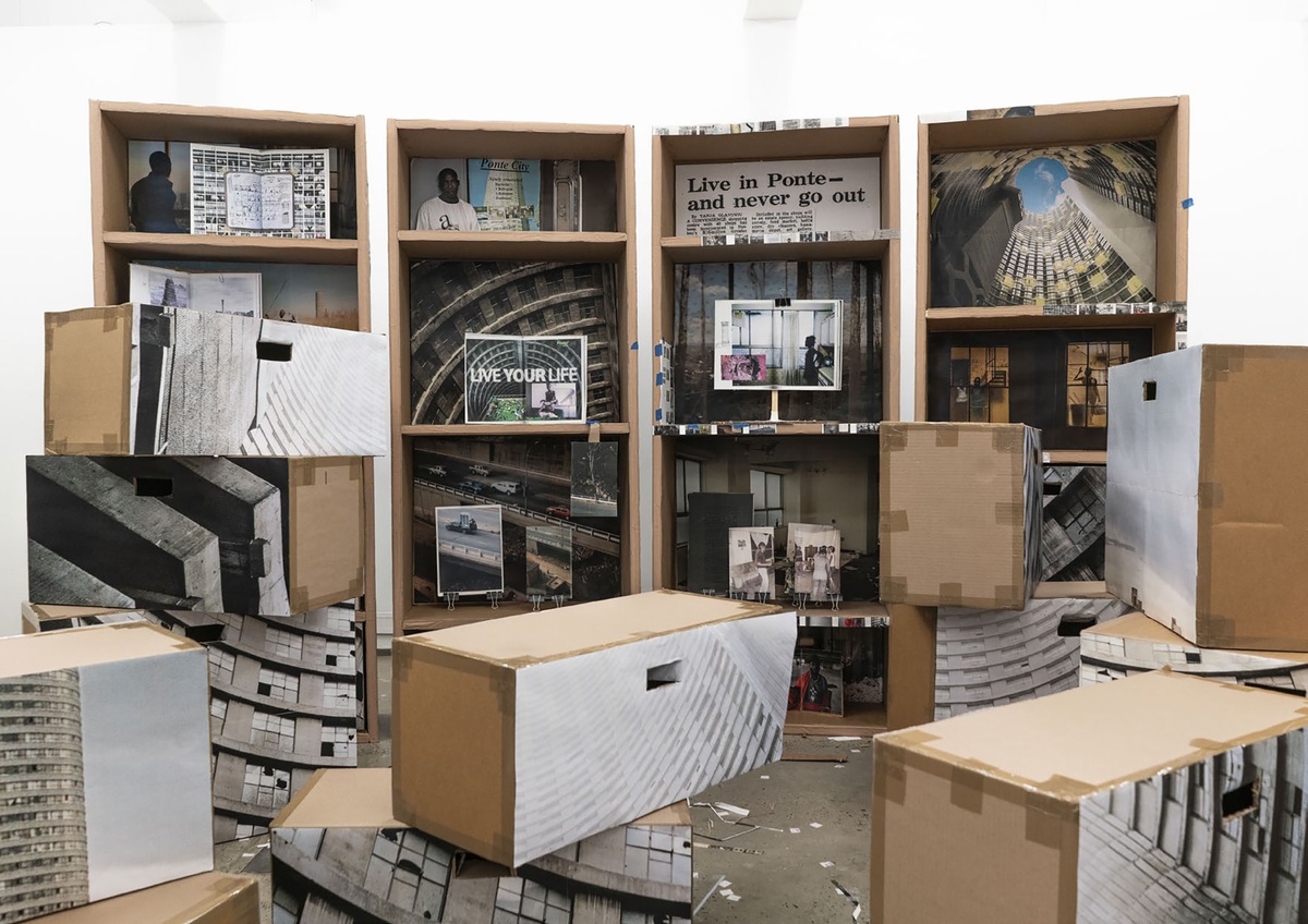 A process photograph shows display boxes for the Ponte City archive by Mikhael Subotzky and Patrick Waterhouse made from cardboard and paper printouts.
