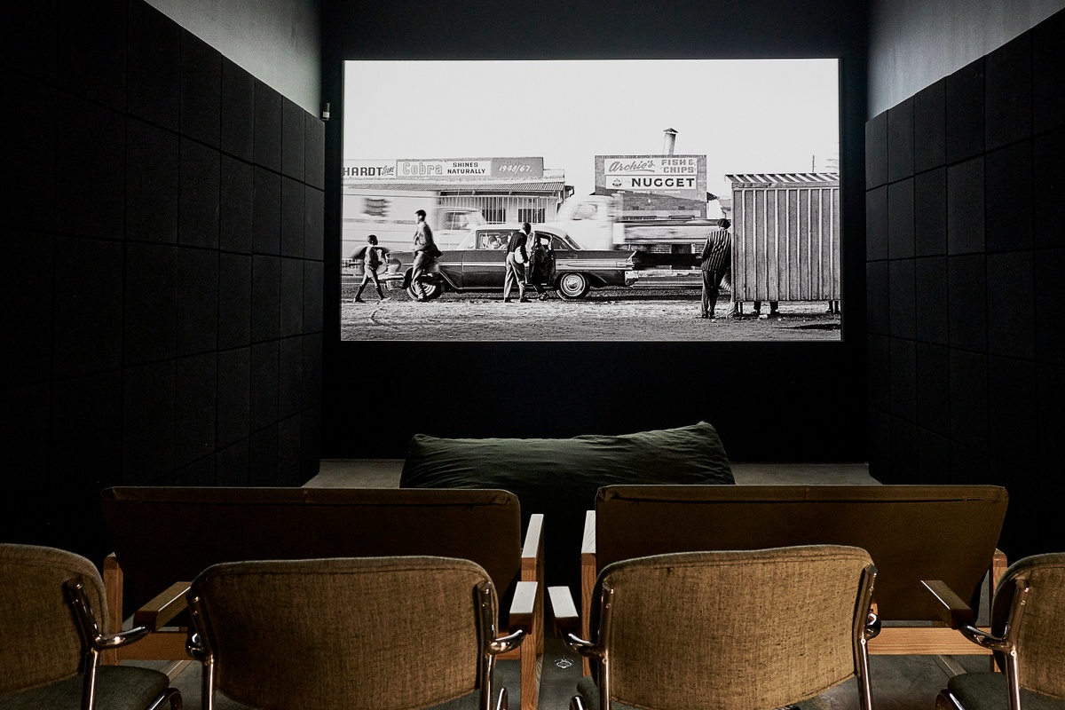 Installation photograph from the ‘Picture Theory’ exhibition in A4’s Gallery. At the back, Daniel Zimbler’s film ‘Goldblatt: A Documentary’ is projected onto the wall in the darkened video room.
