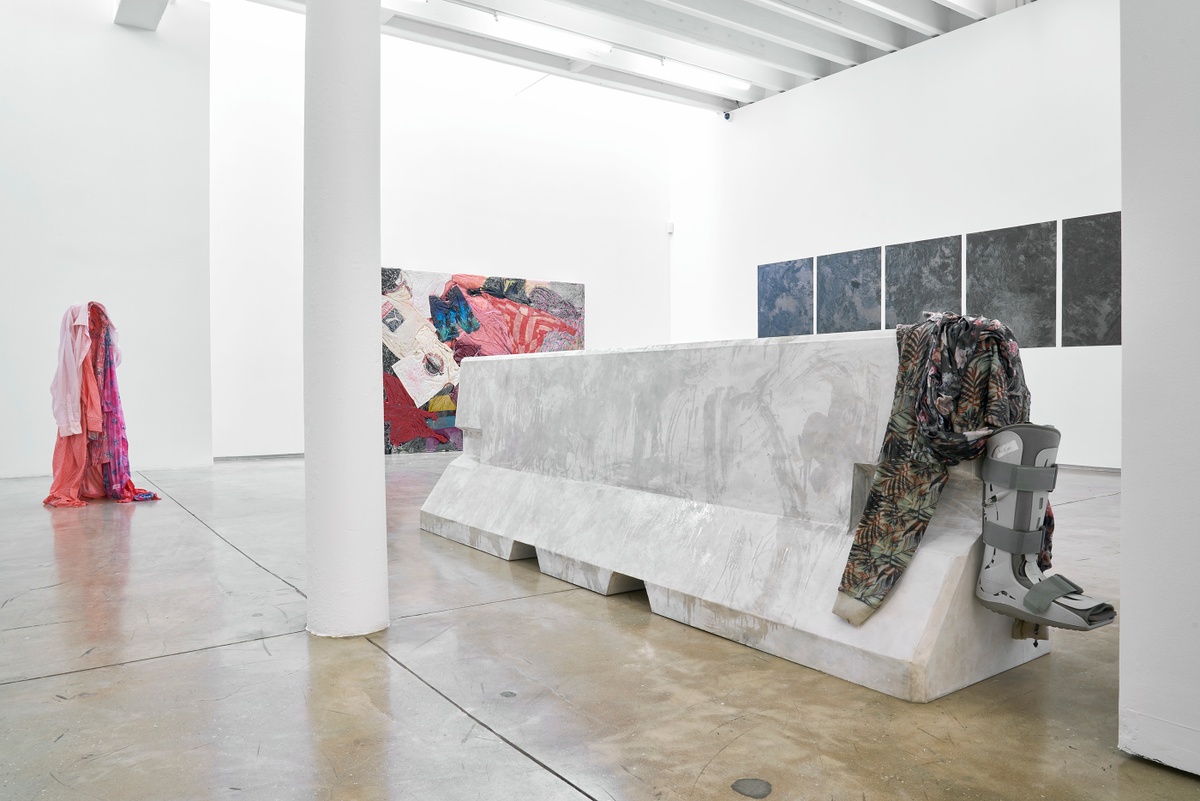 Installation photograph from the ‘without a clear discernible image’ exhibition in A4’s Gallery. On the right, Kevin Beasley’s untitled plywood, paint, resin and garment sculpture sits on the gallery floor. On the left, Beasley’s untitled resin and garment sculpture stands on the gallery floor.
