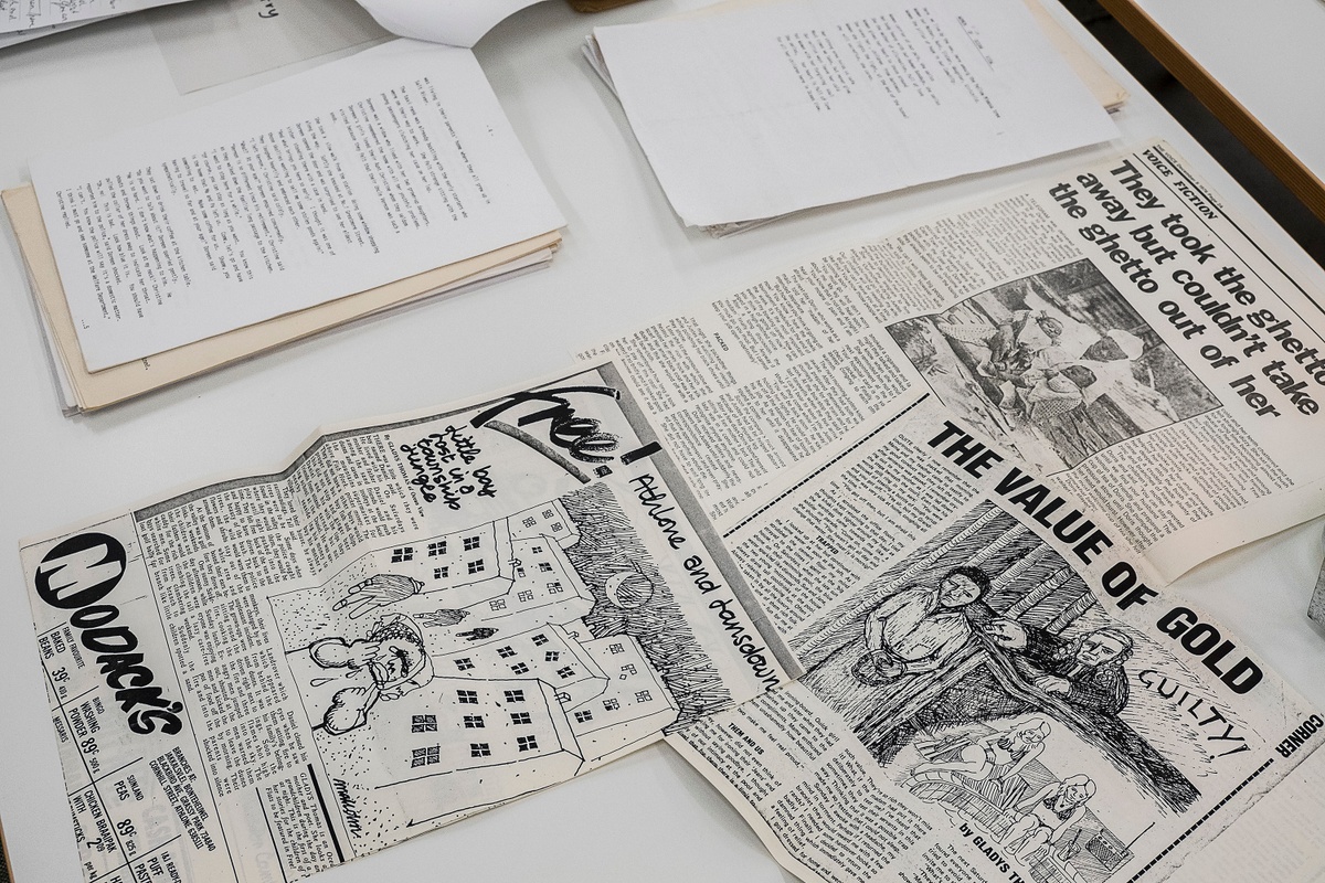 Installation photograph from the ‘Gladiolus’ exhibition on A4’s ground floor that shows printed matter arranged on a table. On the left, a stapled copy of Gladys Thomas’ ‘A walk along the promenade’. On the right, a photocopy of Thomas’ short story ‘Little boy lost in a township jungle’.
