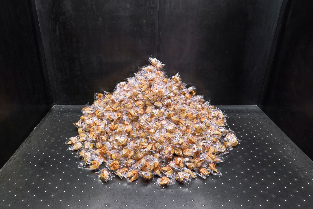 Installation photograph of Felix González-Torres' ‘Untitled (Fortune Cookie Corner)’ in A4’s elevator, with wrapped fortune cookies piled against the back of the interior.
