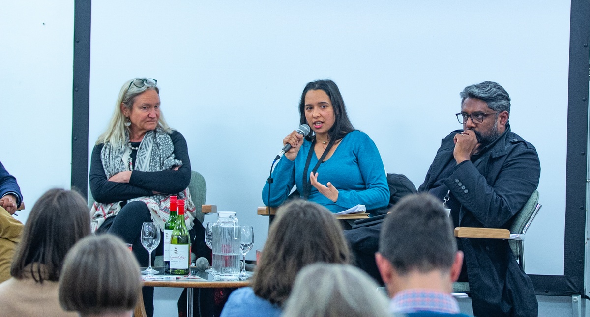Event photograph from the 2018 rendition of the Open Book festival on A4’s ground floor. At the front, seated attendees. At the back, a panel comprised of Kate Philip, Tracey Jooste and Nishendra Moodley.
