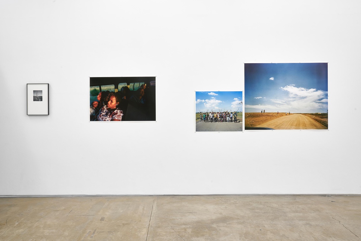 Installation photograph from the ‘Tell it to the Mountains’ exhibition in A4’s Gallery. Lindokuhle Sobekwa’s monochrome photograph ‘Makhulu ehlakula egadini’ and colour photographs ‘Ziyaphuma ezicweleyo’, ‘Amakhwenkwe’ and ‘Tsojana bus stop’ are mounted on the wall.
