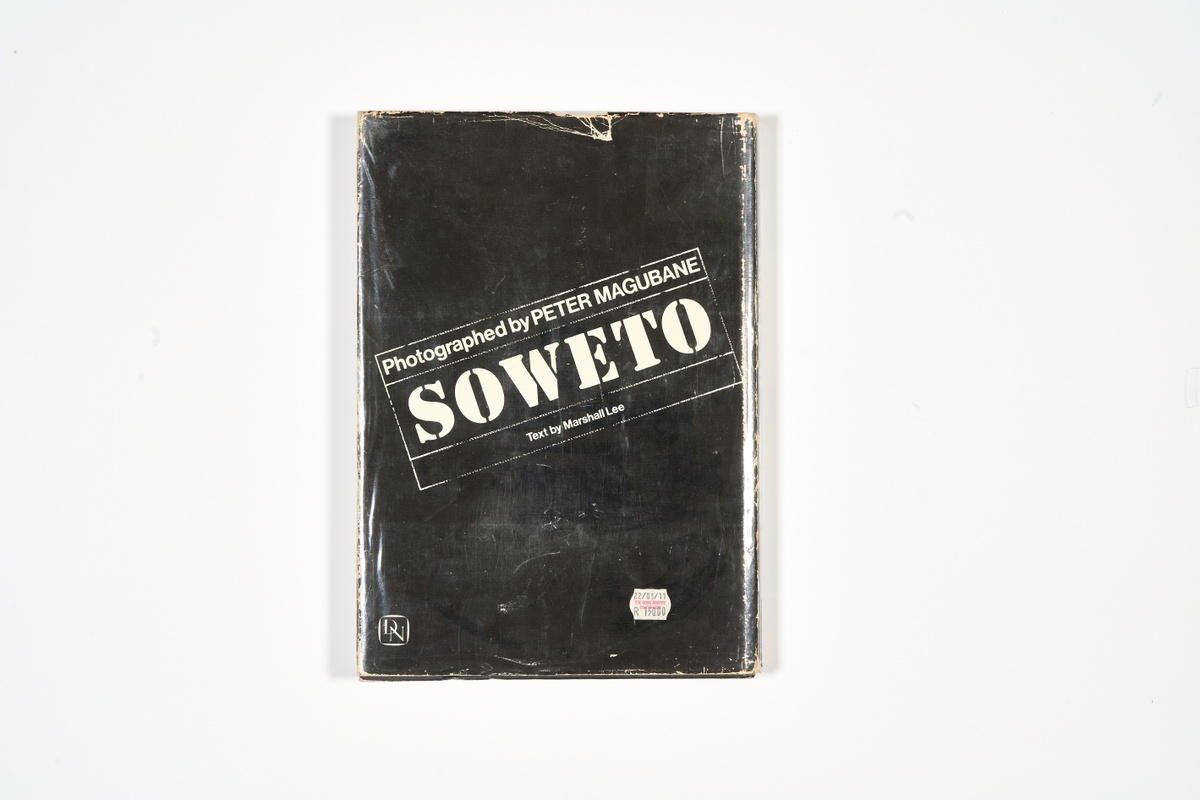 A topdown photograph of the back cover of Peter Magubane's photo-book 'Soweto' on a white background.
