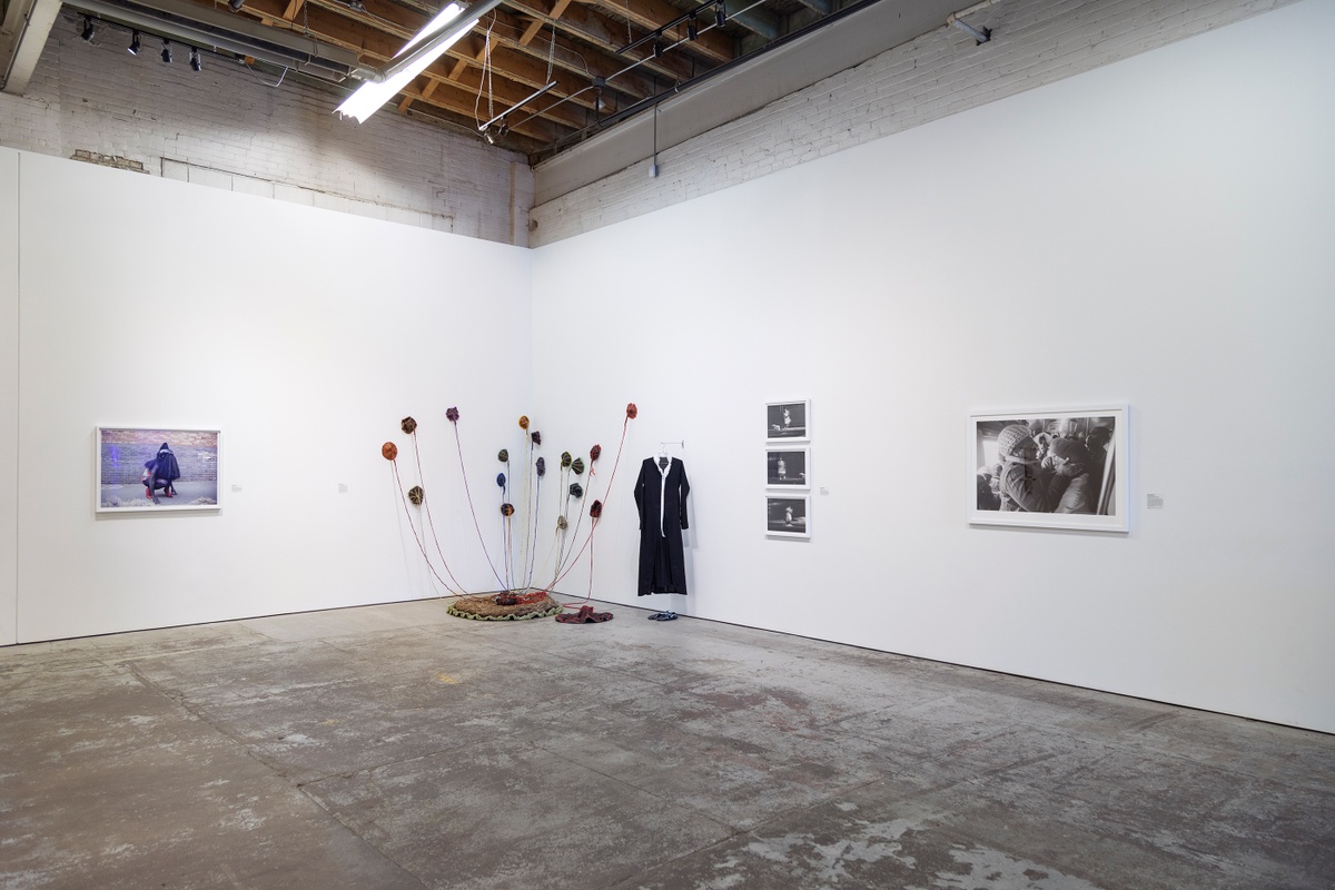 Installation photograph from ‘Crossing Night: Regional Identities x Global Context’ exhibition at the Museum of Contemporary Art Detroit. On the left, Athi-Patra Riga’s photograph ‘The Naivety of Beiruth’ is mounted on the gallery wall. In the middle Nicholas Hlobo’s installation/performance piece ‘Thoba, utsale emnxeba’ occupies the corner of the gallery. On the right, three photographs from Sabelo Mlangeni’s series ‘Invisible Woman’ and Santu Mofokeng’s photograph ‘Supplication Soweto Line - Jhb’ is mounted on the gallery wall.
