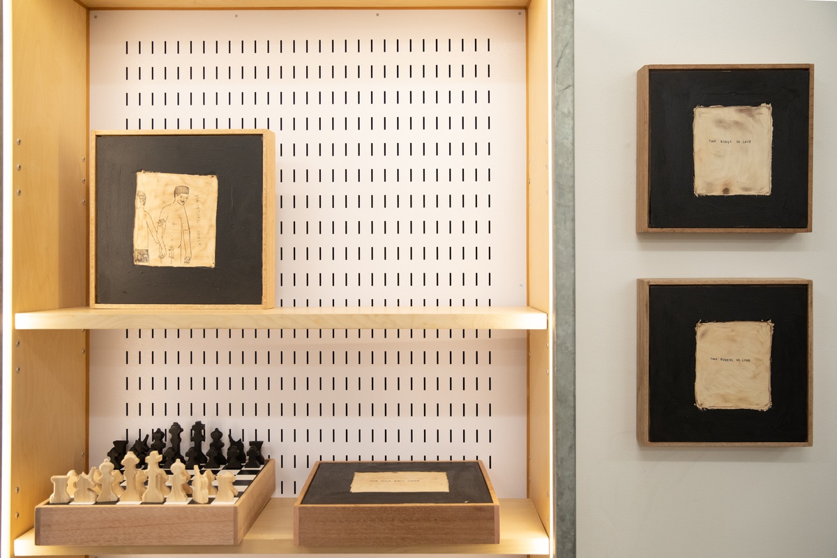 Event photograph from the launch of Brett Seiler’s chess set in A4’s Proto museum shop. On the left, three of Seiler's chess sets are arranged in a cabinet. On the right, two of Seiler's chess sets are mounted on the wall.
