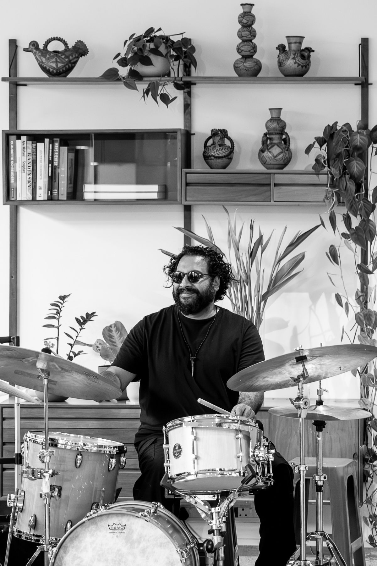 Event photograph from the preview of the 'A Little After This' exhibition in A4 Arts Foundation that shows the drummer from The Regulars Jazz Trio performing on the top floor.
