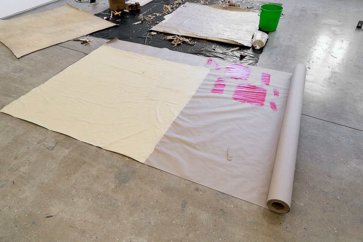 Process photograph from the 2nd rendition of ‘Parallel Play’ in A4’s Gallery. In Asemahle Ntlonti’s working space sheets of brown paper are arranged on the gallery floor in the process of being painted.
