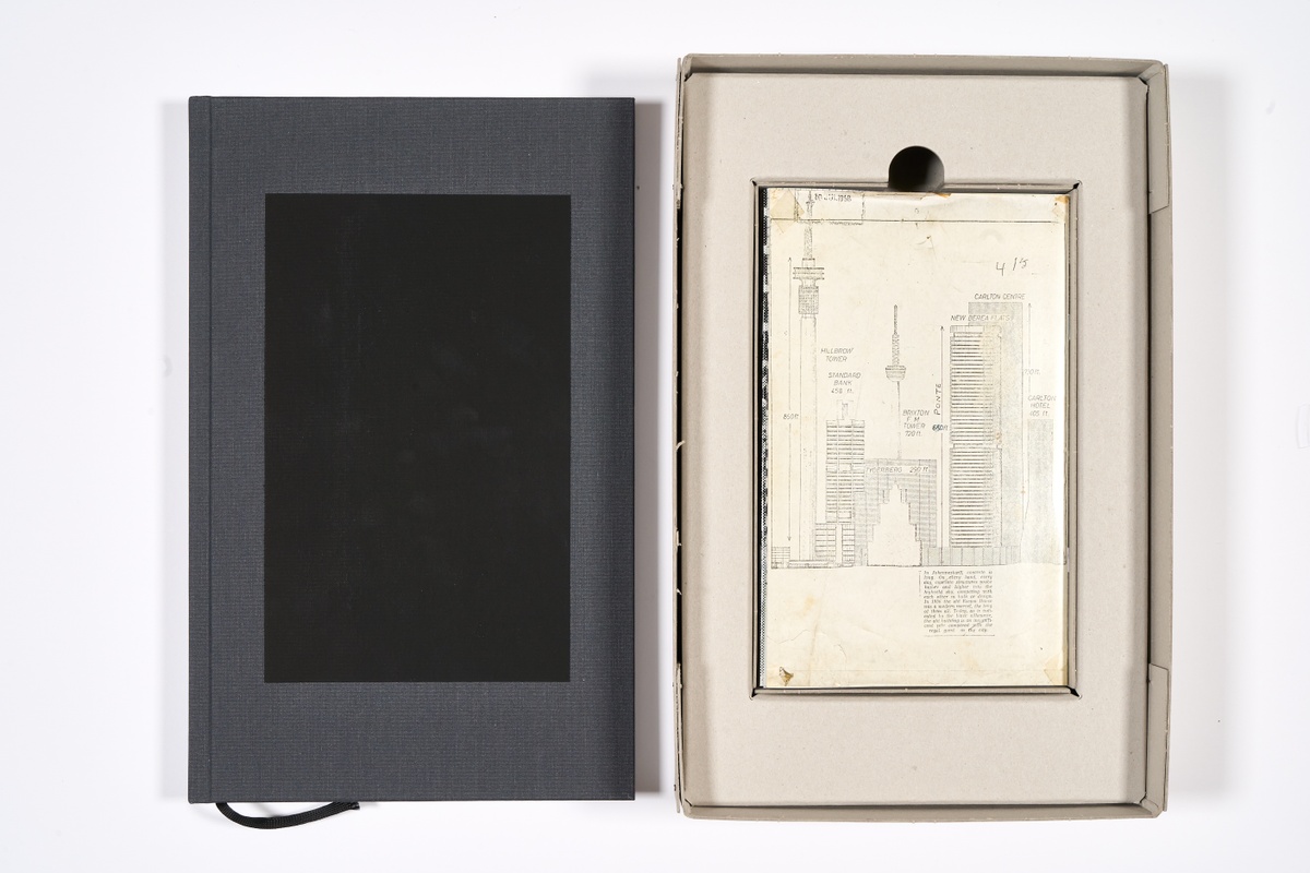 A topdown photograph that shows the front cover (on the left) and the inside of the packaging (on the right) for Mikhael Subotzky and Patrick Waterhouse's photo-book 'Ponte City' on a white background.

