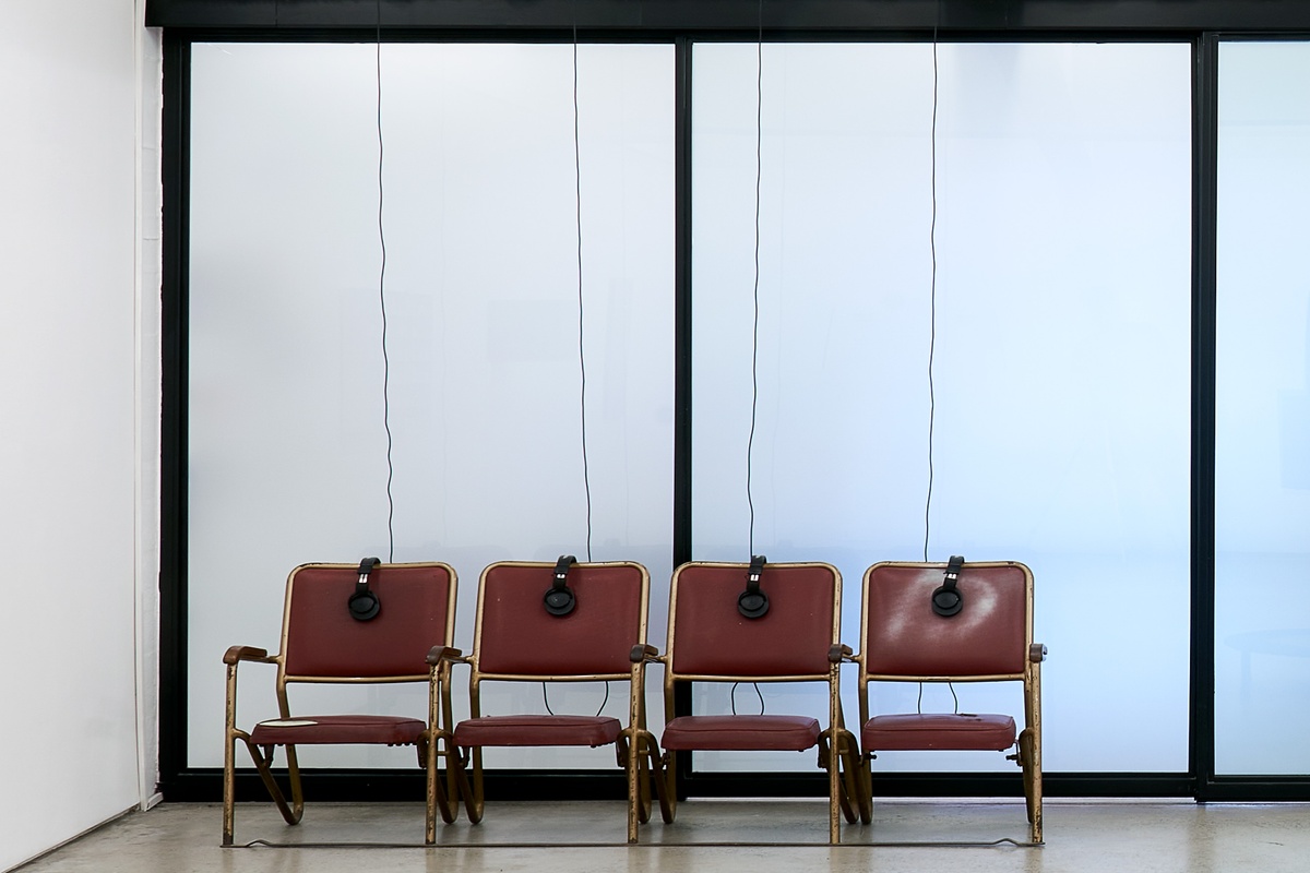 Installation photograph from the ‘Model’ exhibition in A4’s Reading Room. Bhavisha Panchia sound installation 'Imagine you're in a museum: What do you hear?' consists of four chairs with headphones.
