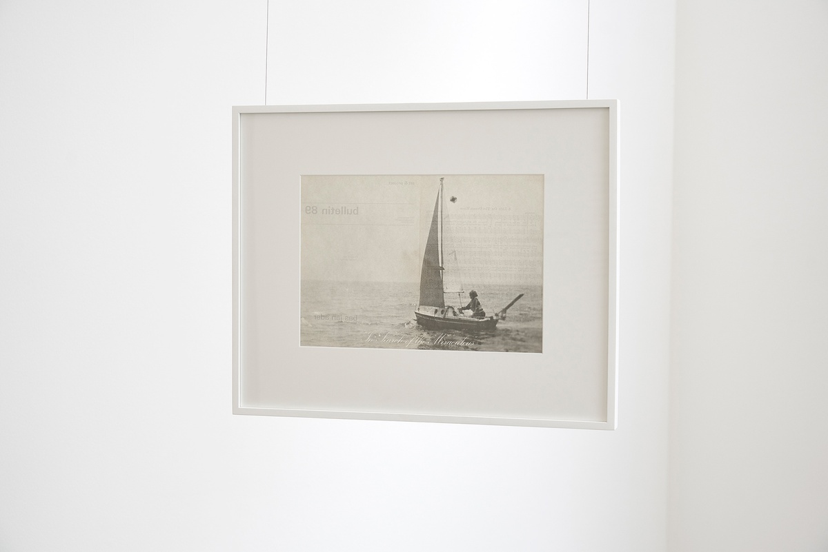 Installation photograph that shows Bas Jan Ader’s framed ‘Bulletin 89, in search of the miraculous (songs for the north atlantic)’ suspended from the ceiling.
