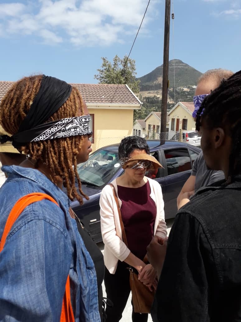 Process photograph from the offsite ‘Ghetto Relay - Lalela experiment’ exchange in Imizamo Yethu, Hout Bay that shows blindfolded participants standing on the side of a street.
