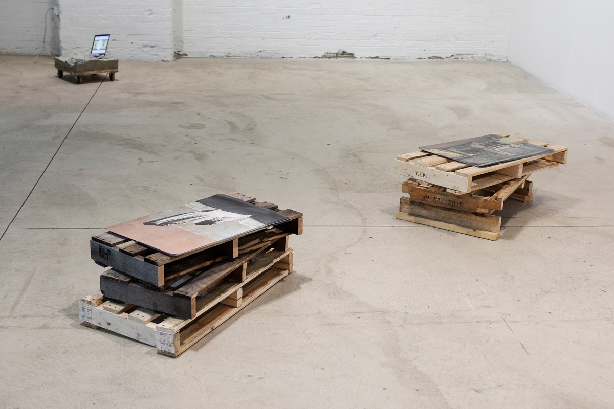Installation photograph from ‘Crossing Night: Regional Identities x Global Context’ exhibition at the Museum of Contemporary Art Detroit. At the front, Edson Chagas’ photograph and wooden pallet installation ‘Found, not taken’ sits on the gallery floor.
