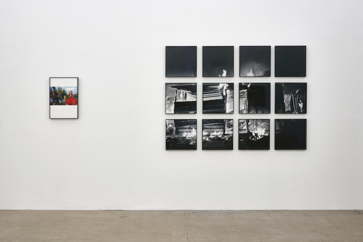 Installation photograph from the ‘Tell it to the Mountains’ exhibition in A4’s Gallery. On the left, Lindokuhle Sobekwa’s colour photograph ‘Jeannie with her sisters’ is mounted on the wall. On the right, Sobekwa’s monochrome photograph ‘Shack of nyaope users is set on fire by an angry group of men that claim they stole their things. Nyaope users are always the first suspects in the communities’ is mounted on the wall.
