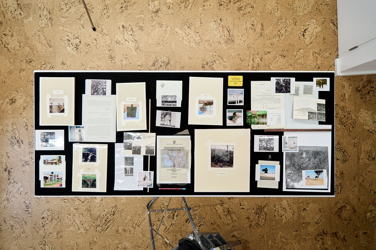 Installation photograph of Michael Tymbios’ studio during his residency in A4 Arts Foundation. A topdown view of a freestanding display case that holds photographs and ephemera.
