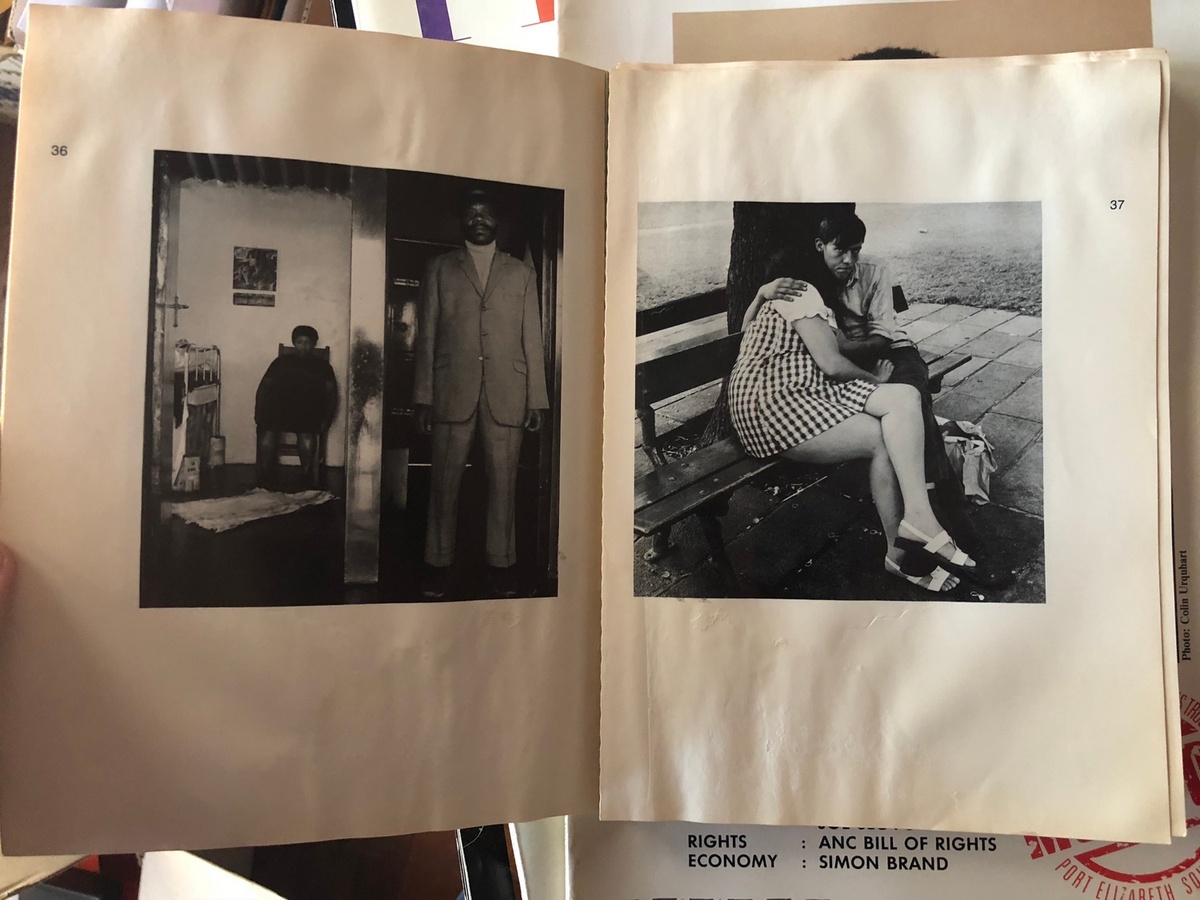 Process photograph from the ‘Picture Theory’ exhibition in A4’s Gallery that shows a closeup view of 2 page spread from a photo-book. On the left, Goldblatt’s monochrome photograph ‘George and Sarah Manyane, 3153 Emdeni Extension, Soweto. August 1972’. On the right, Goldblatt’s monochrome photograph ‘In the Nugget Street Park, Doornfontein, Johannesburg. January, 1973’.
