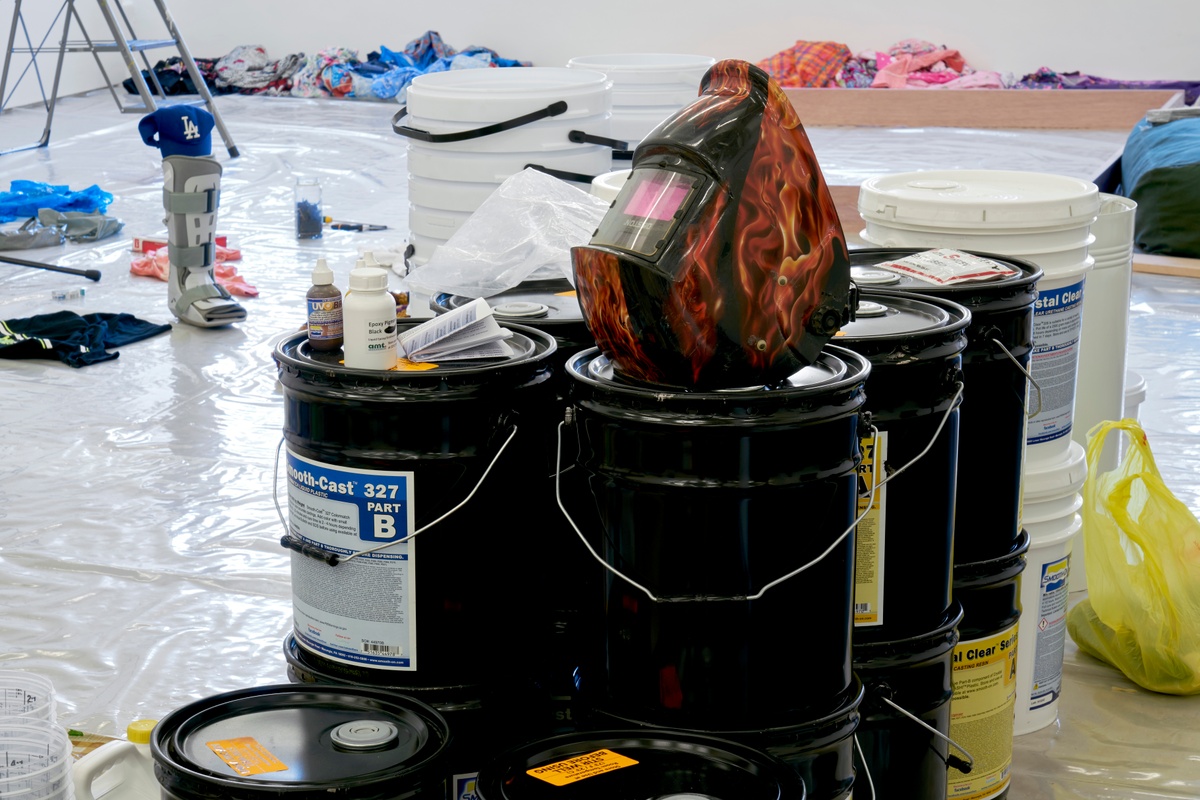 Process photograph from the ‘without a clear discernible image’ exhibition in A4’s Gallery. In the middle, buckets holding liquid components for a resin hardening process are stacked on the gallery floor.
