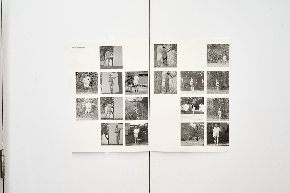 Installation photograph of Michael Tymbios’ studio during his residency in A4 Arts Foundation. A grid of photographic prints on two sheets are mounted on the doors of a white cupboard.
