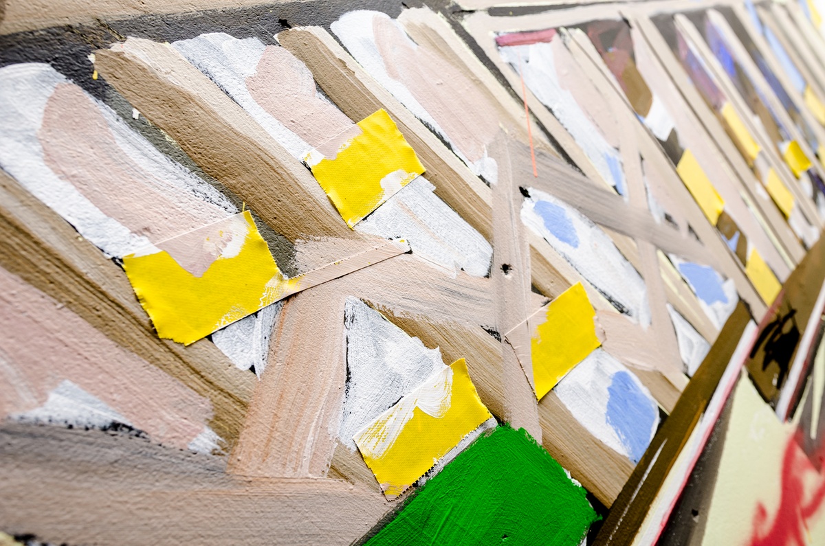 Process photograph from Dorothee Kreutzfeldt’s residency on A4’s 1st floor. A closeup view of a painted mural with strips of yellow gaffer tape.
