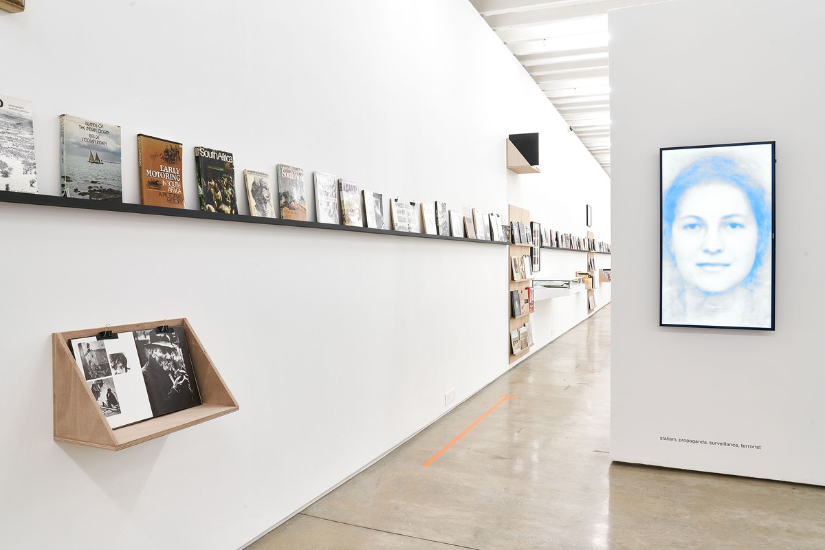 Installation photograph from the Photo Book! Photo-Book! Photobook! exhibition in A4’s Gallery. On the right, Alana Blignaut’s video ‘Mary, Recitation’ is mounted on a wall in an area dedicated to photobooks from the years 1967 to 1994.
