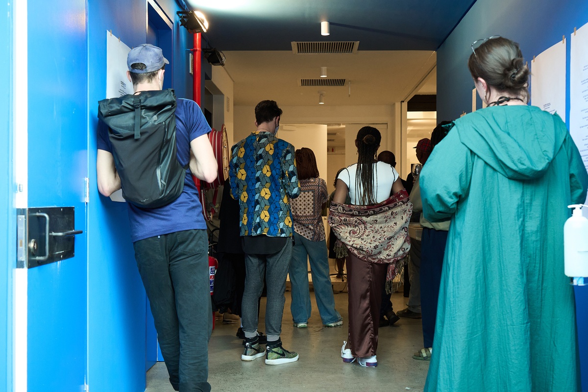 Event photograph from the ‘Umcimbi’ exchange in A4’s Goods project space that shows attendees standing in the Goods corridor.
