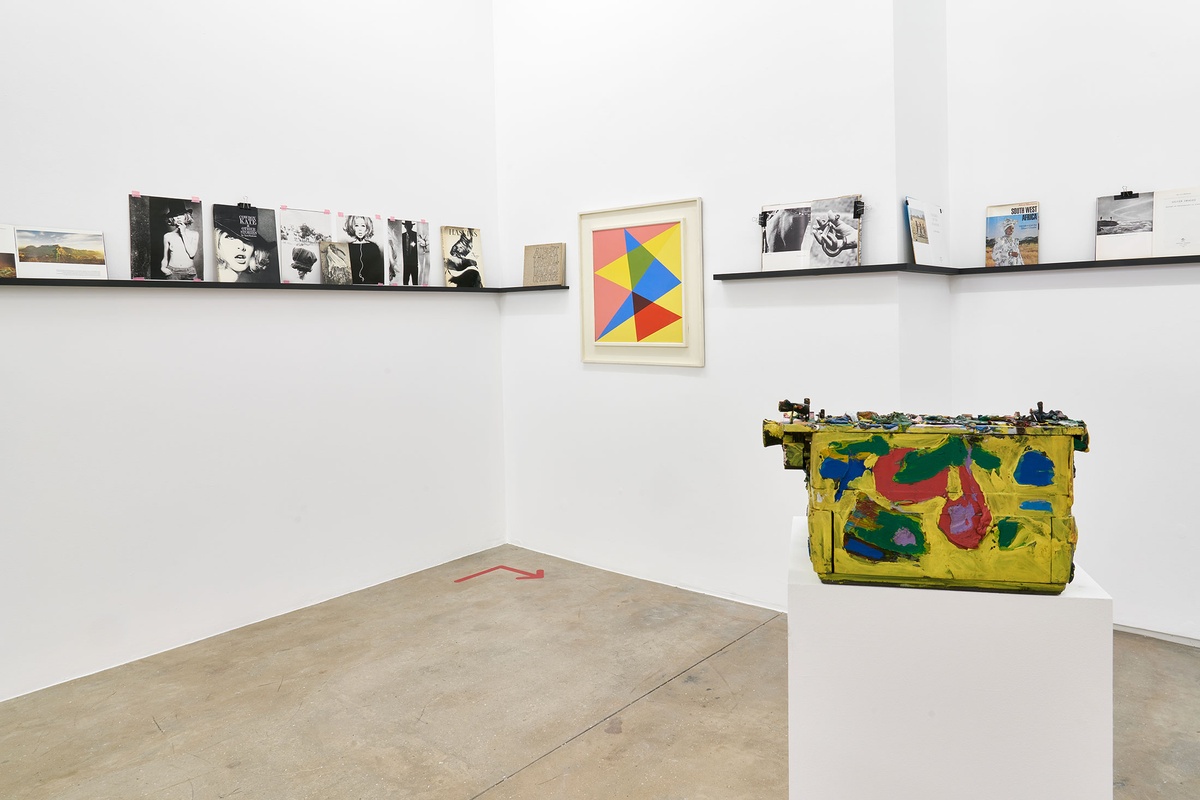 Installation photograph from the Photo Book! Photo-Book! Photobook! exhibition in A4’s Gallery in an area dedicated to photobooks from the years 1945 to 1967. On the left, Albert Newall’s oil painting ‘Harmonic Development within a Square’ hangs on the wall. On the right, Walter Battiss’ oil and mixed media sculpture ‘My Typewriter’ sits on a plinth.
