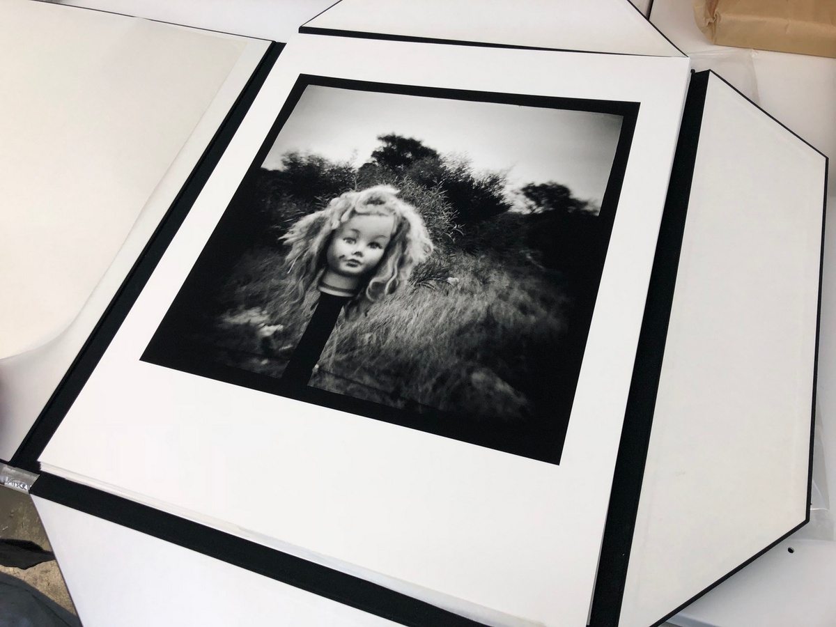 Process photograph from the offsite exhibition ‘Hay Tiempo, No Hey Tiempo’ at the Centro Fotográfico Álvarez Bravo, Mexico. A print of Jo Ratcliffe’s photograph ‘Doll's head’ lays within a folder.
