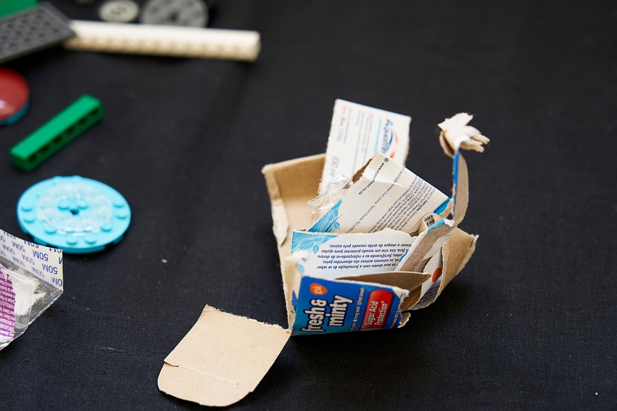 Ephemera from the ‘African Centre for Cities: City Research Studio’ exchange on A4’s top floor. A photograph that depicts a small pile of cardboard scraps with branding on a black table cloth.
