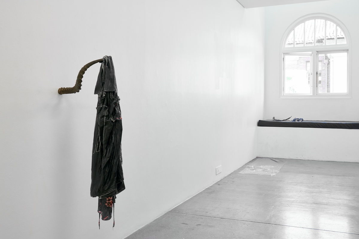 Installation photograph from the ‘without a clear discernible image’ exhibition in A4’s Gallery. On the left, Kevin Beasley’s untitled resin and garment sculpture is mounted on the wall on an antelope horn.
