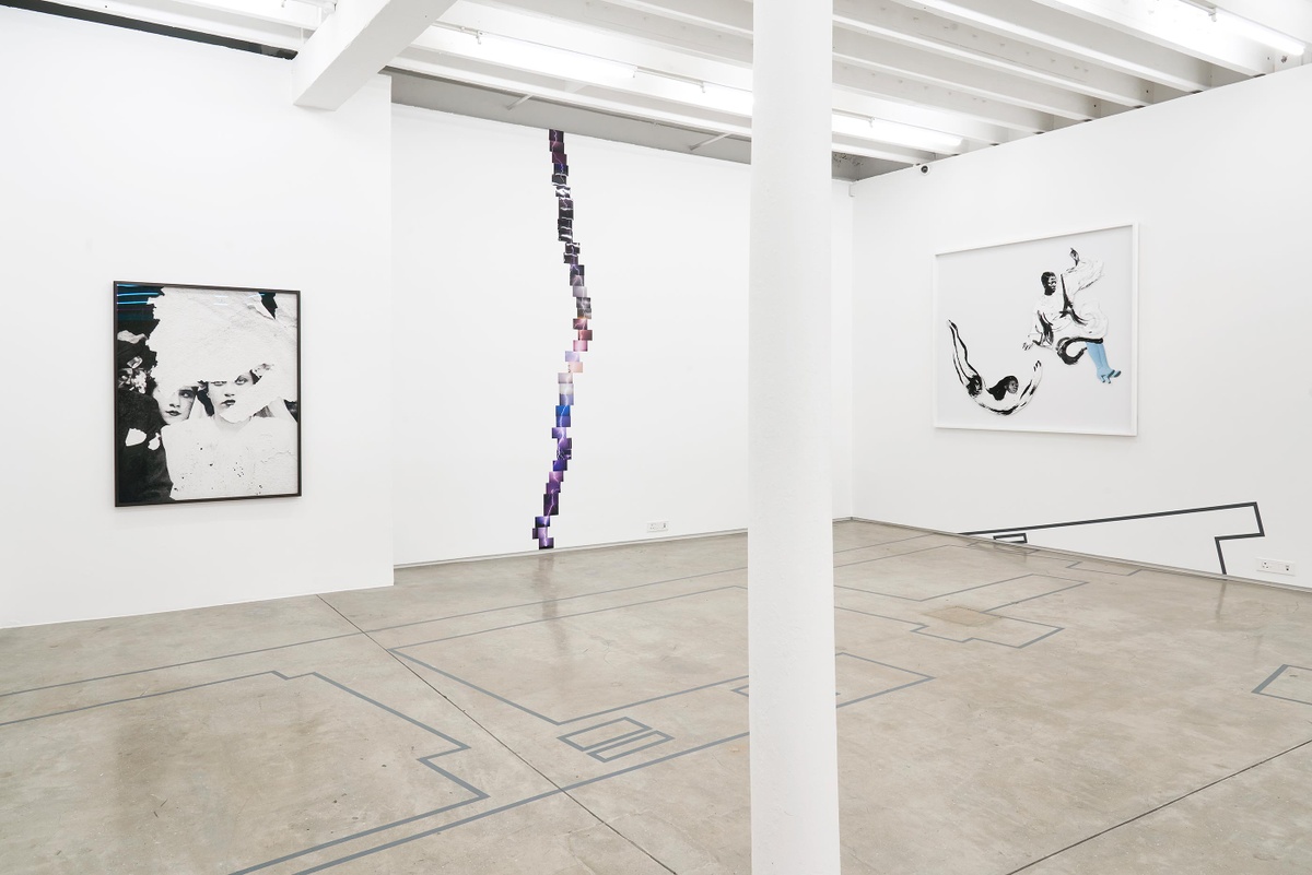 Installation photograph from the Customs exhibition in A4’s Gallery. On the left, Dor Guez’s framed monochrome photographic print ‘Samira’ is mounted on a white gallery wall. In the middle, Kapwani Kiwanga’s photographic series ‘Ground’ is mounted on a white gallery wall in the shape of a lightning strike. On the right, Frida Orupabo’s framed collage ‘Going home’ is mounted on a white gallery wall.
