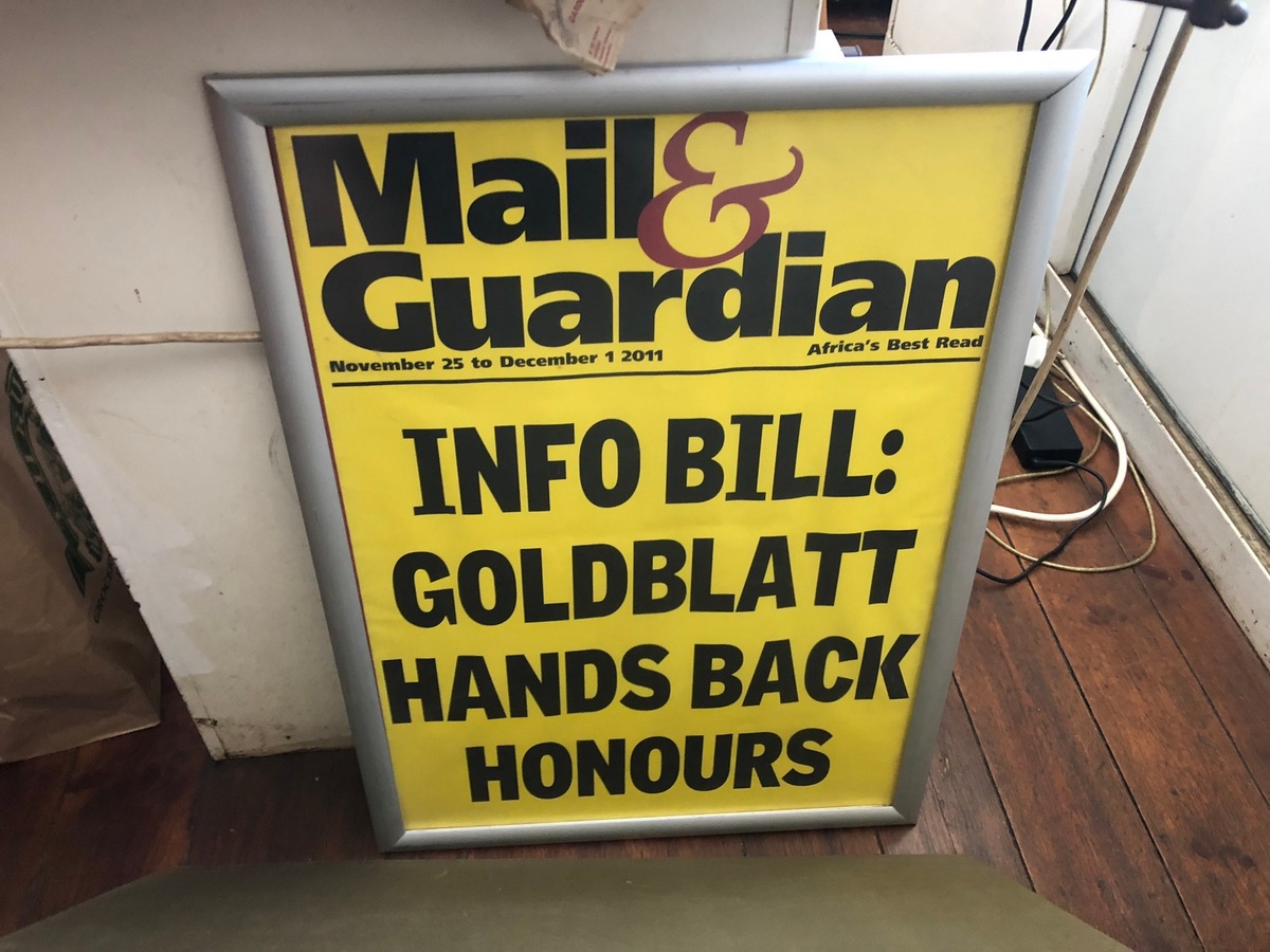 Process photograph from the ‘Picture Theory’ exhibition in A4’s Gallery. A framed poster of a headline from the November 25 to December 1, 2011 Mail & Guardian that reads “Info Bill: Goldblatt hands back Honours” that leans against a wall.
