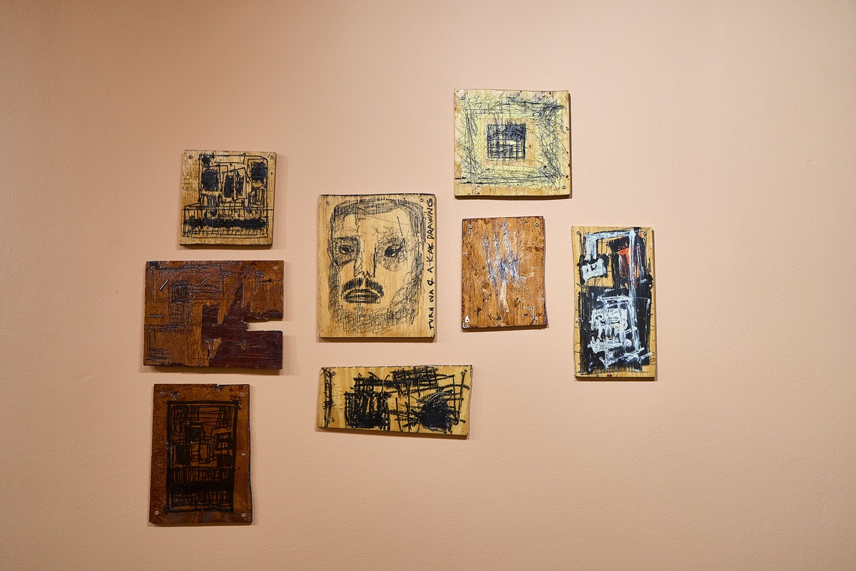 Installation photograph from Phillip Newman's exhibition in A4 Arts Foundation's Goods space shows drawings on small wooden panels mounted on the wall.
