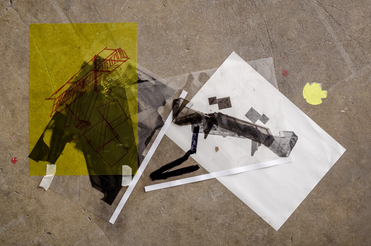 Process photograph from Dorothee Kreutzfeldt’s residency on A4’s 1st floor. A printed photographic collage overlaid with transparent sheets of plastic with felt pen marker drawings sits on a concrete floor.
