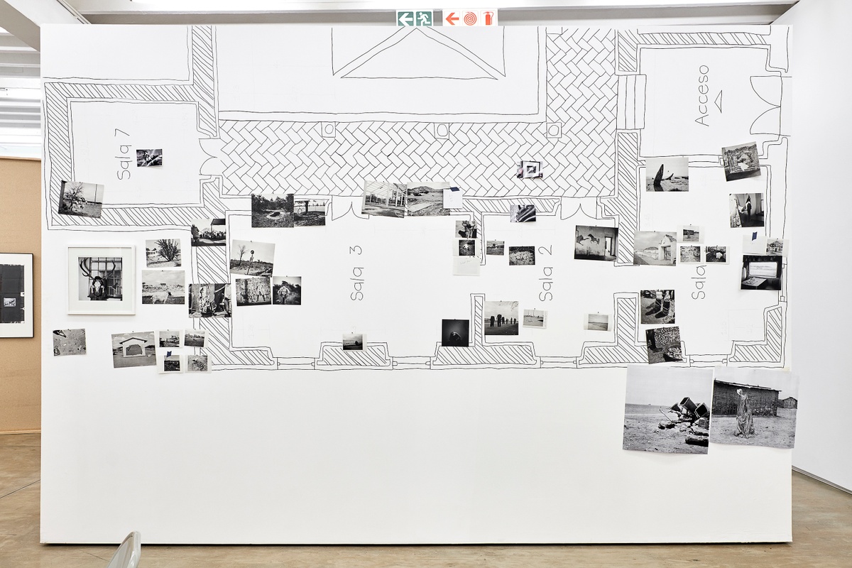 Installation photograph from the 2018 rendition of ‘Parallel Play’ in A4’s Gallery. A moveable gallery wall is features the sketched layout of an exhibition space, with photographic prints from Jo Ractliffe’s archive pinned on top of it.
