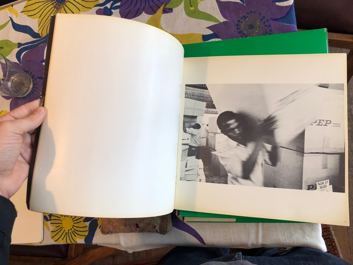 Process photograph from the ‘Picture Theory’ exhibition in A4’s Gallery that shows a hand holding open a photo-book.
