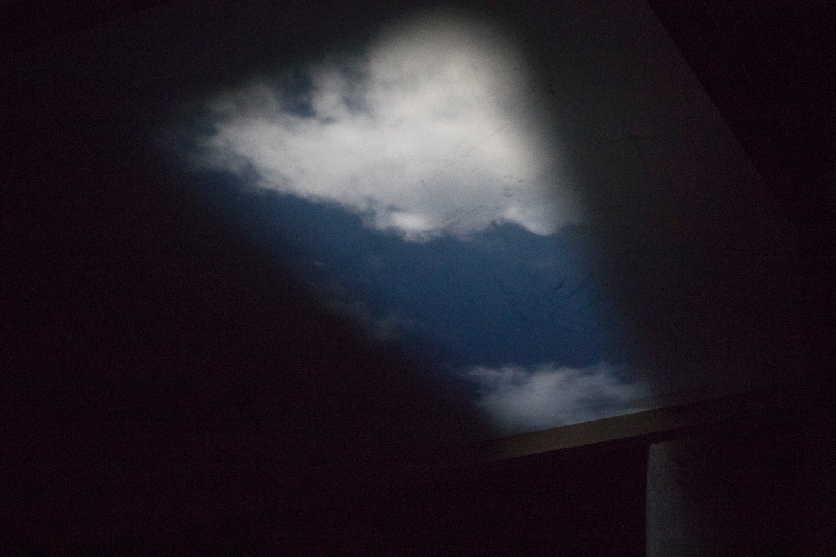 Installation photograph from George Mahashe’s ‘Camera Obscura #3’ exhibition on A4’s top floor that shows a pinhole camera projection of a swathe of cloudy sky.
